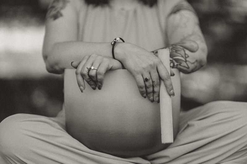 Black and white photograph of hands resting on a crystal singing bowl held in the lap