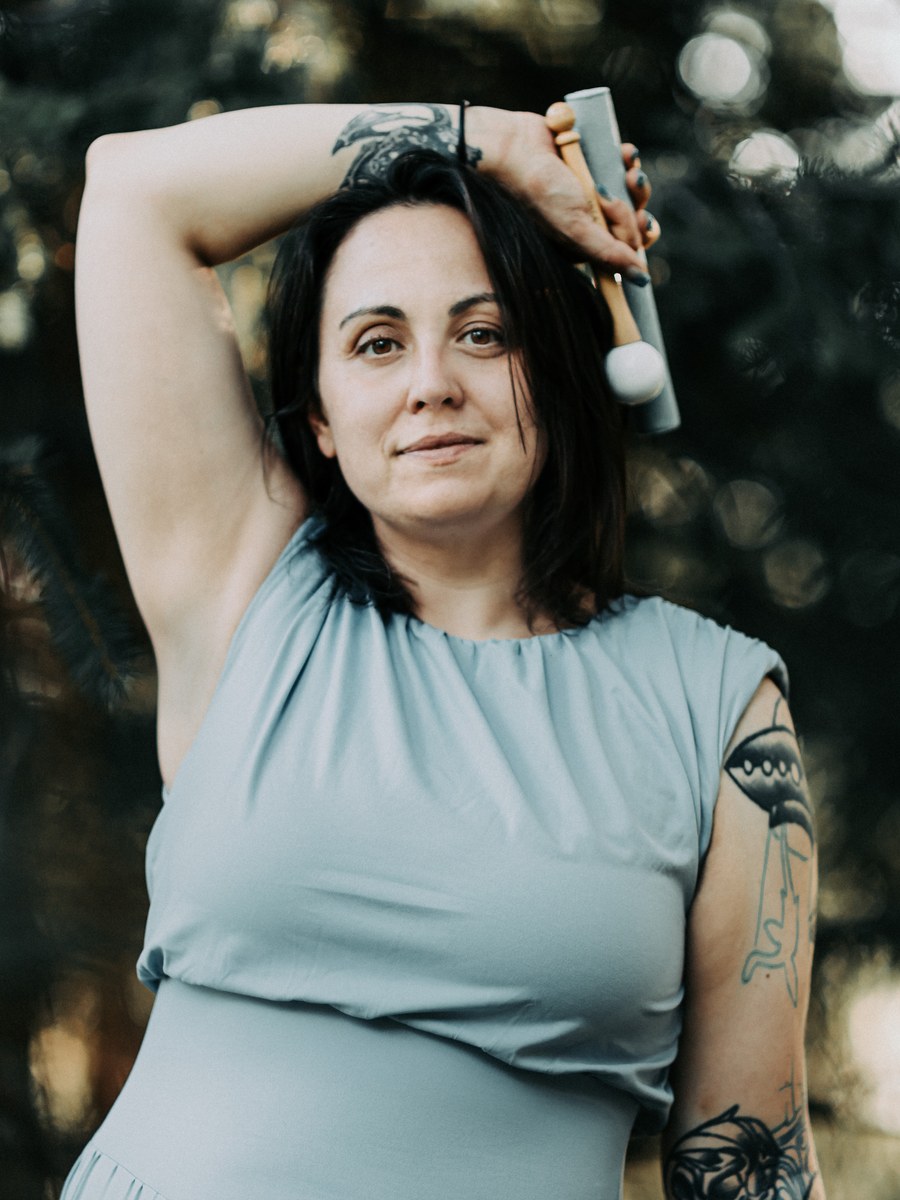 Mallory Bey, ordained aura reader and energy healer, outdoors holding a sound bowl mallet